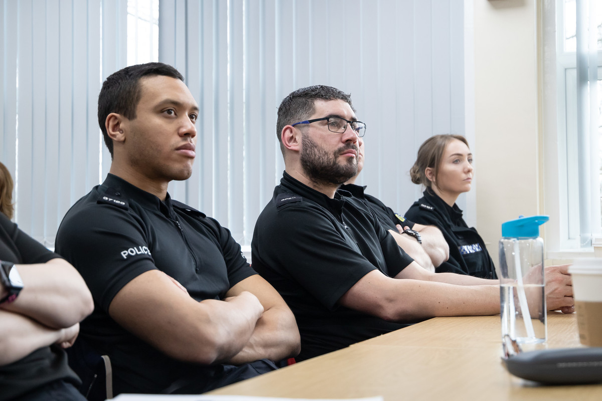 policing students sat at table in uniform