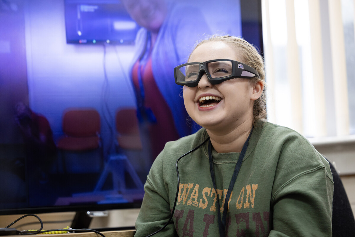 Student smiling while using eye tracker during a Psychology equipemnet demo