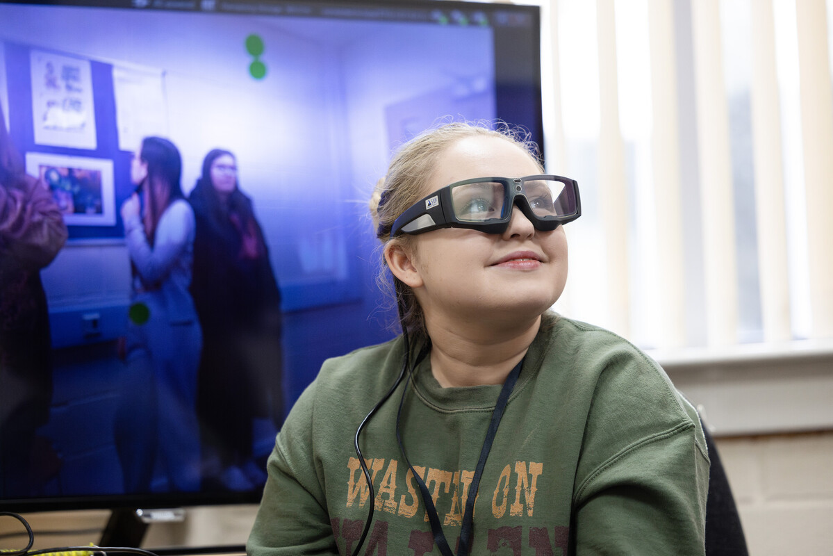 Student smiling while using eye tracker during a Psychology equipemnet demo
