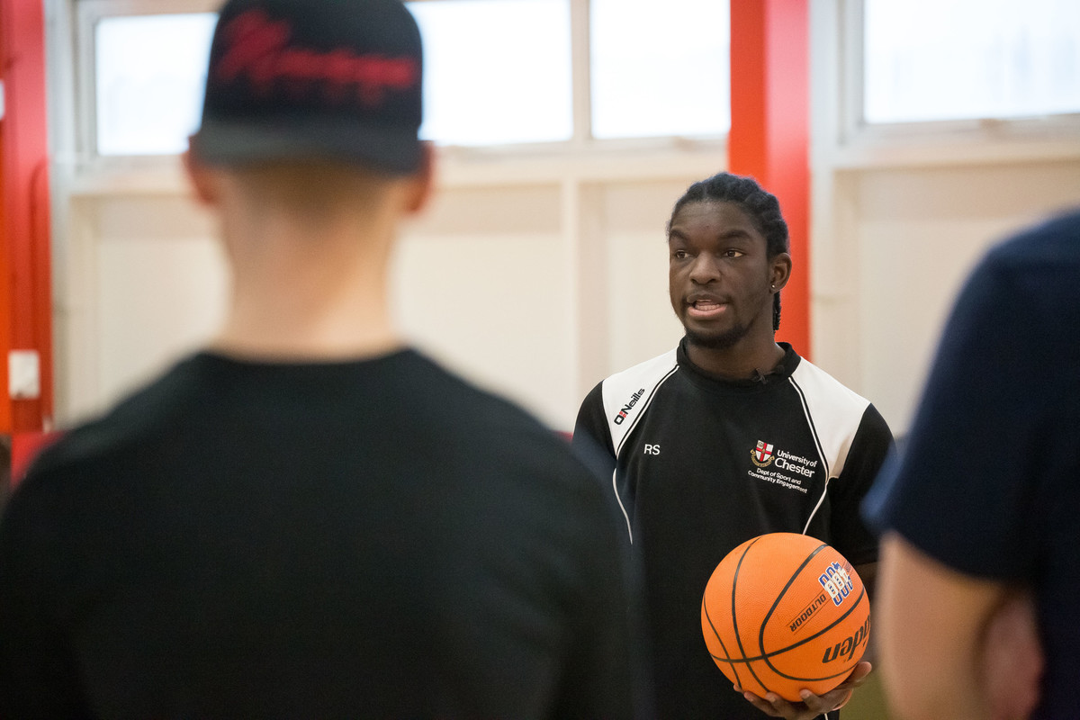 student with basketball indoors