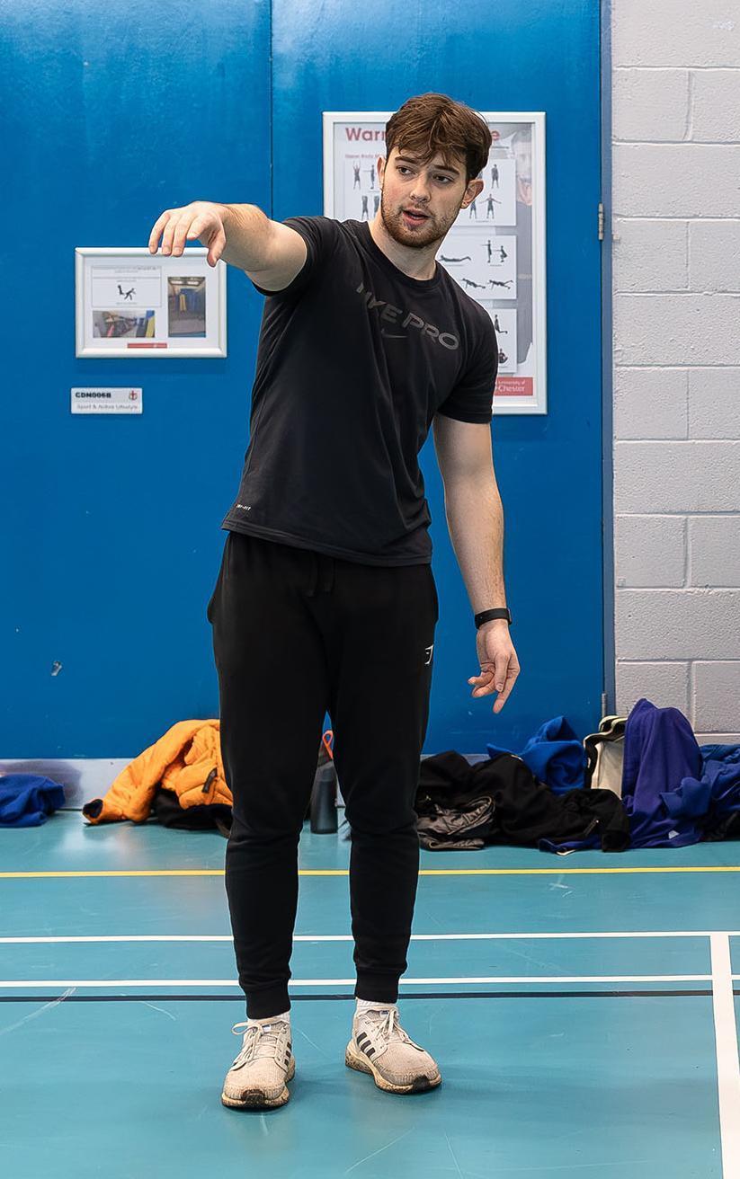 University of Chester PE and Sports Coaching BSc Hons student leading a primary school hockey session, developing practical teaching and coaching skills in a sports hall.
