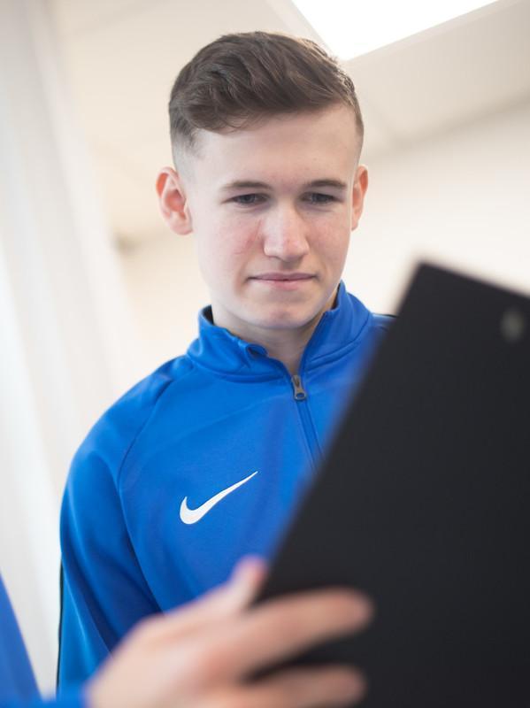 Sports Medicine MSc students reviewing athlete assessment data on a digital tablet in a clinical learning environment, demonstrating evidence-based practice, sports injury management, performance monitoring and applied sports medicine research.