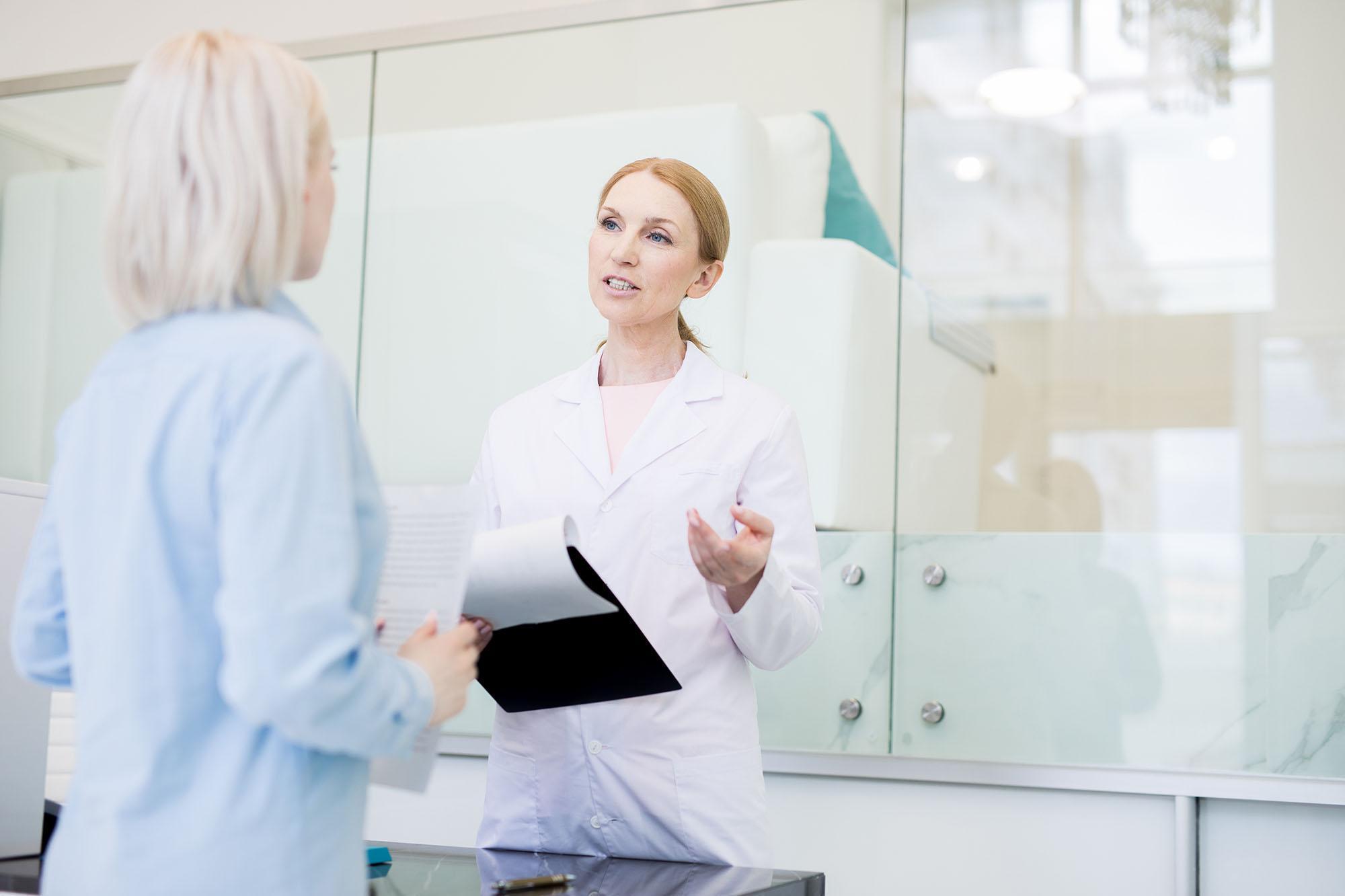 Healthcare professional discussing patient care documentation in a modern clinical setting, illustrating leadership, healthcare operations and strategic healthcare management for the Health Services Management MSc at the University of Chester.