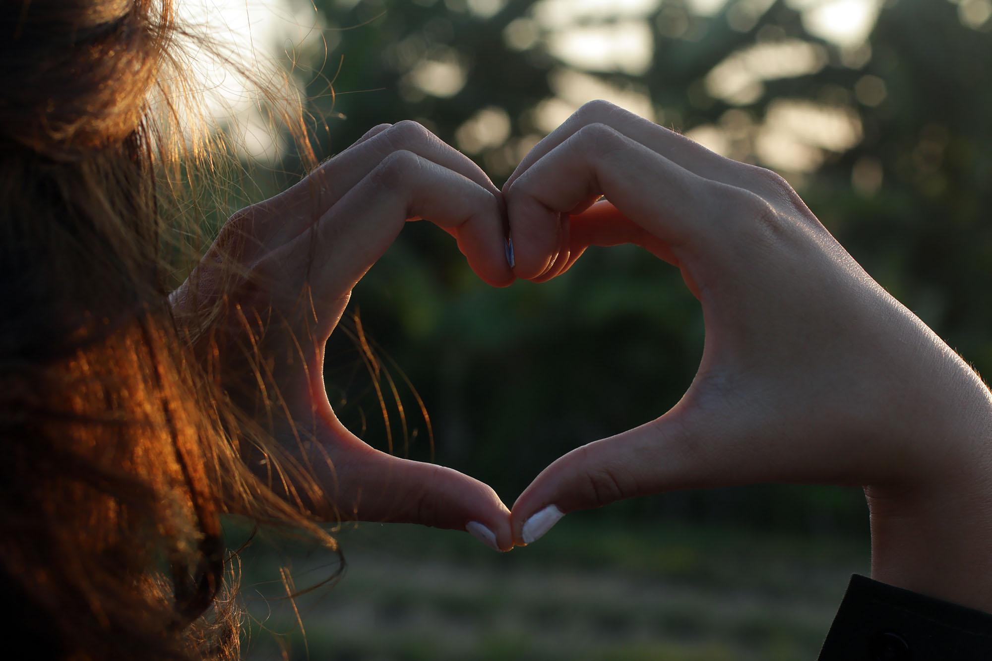 Hands forming a heart shape outdoors, symbolising inclusivity, equality and social connection in gender studies research, reflecting themes explored in the Gender Studies MRes programme.
