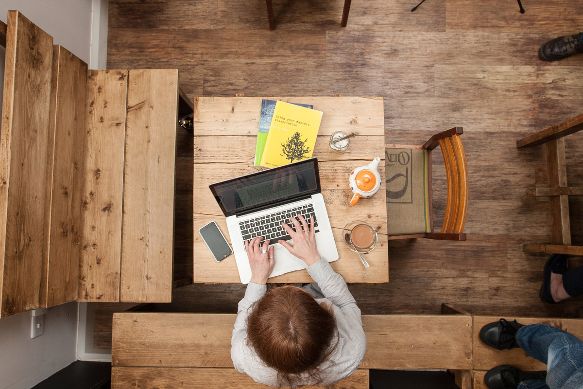 A student sitting at a table using a laptop
