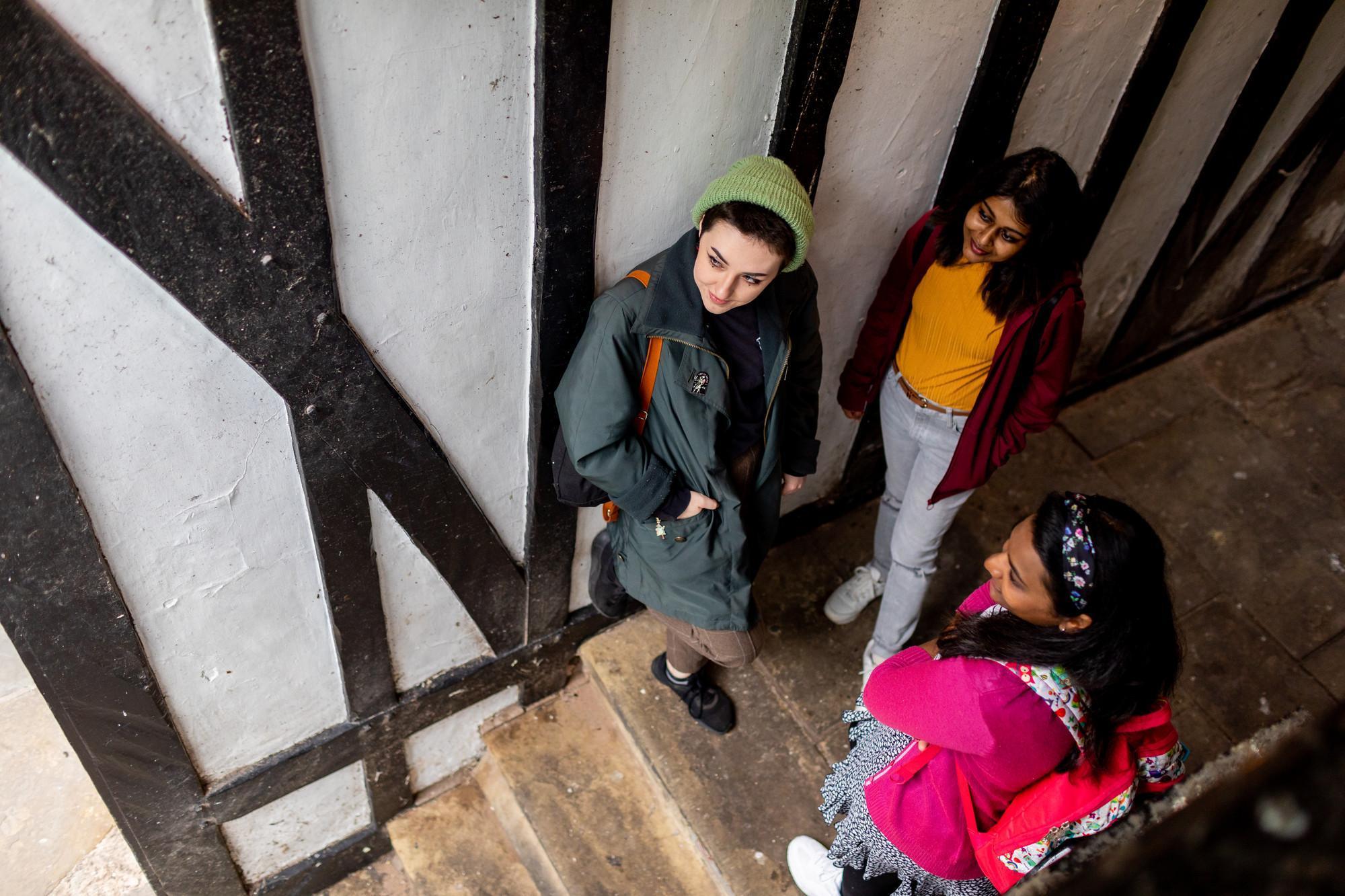 History MA students exploring a historic timber-framed building, engaging with heritage sites, historical research and the study of local and global history as part of postgraduate history studies.