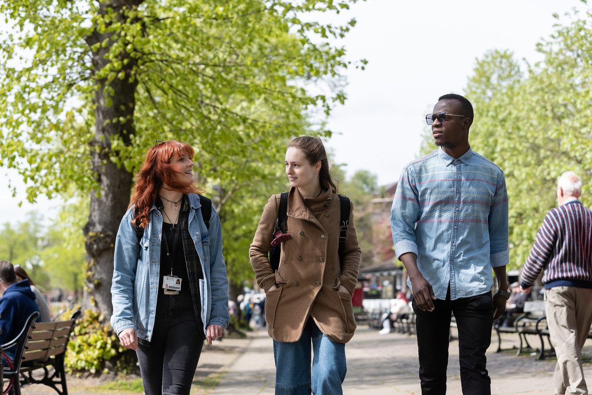 A group of students walking outside in the park.