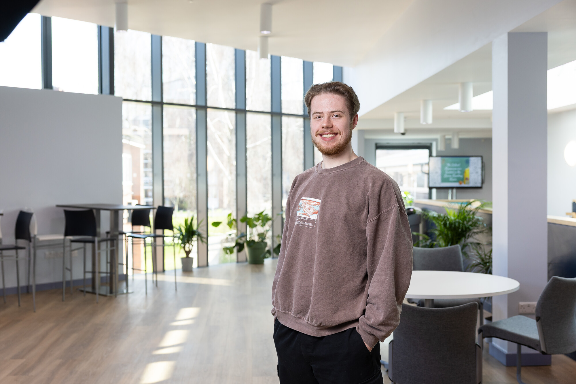 student standing in library foyer