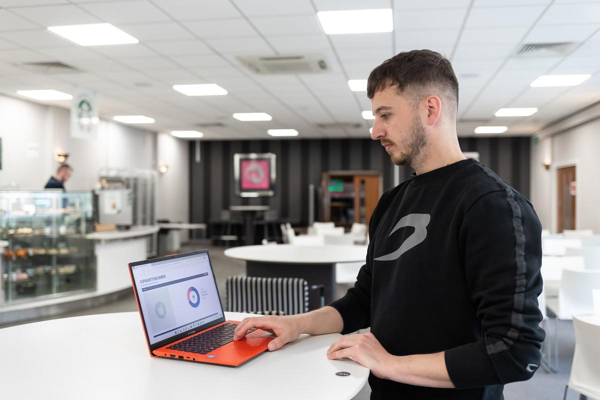 Professional Development by Negotiated Studies MA/MSc/MBA student using a laptop in a modern study space, showcasing flexible postgraduate learning, workplace development and career progression at the University of Chester.