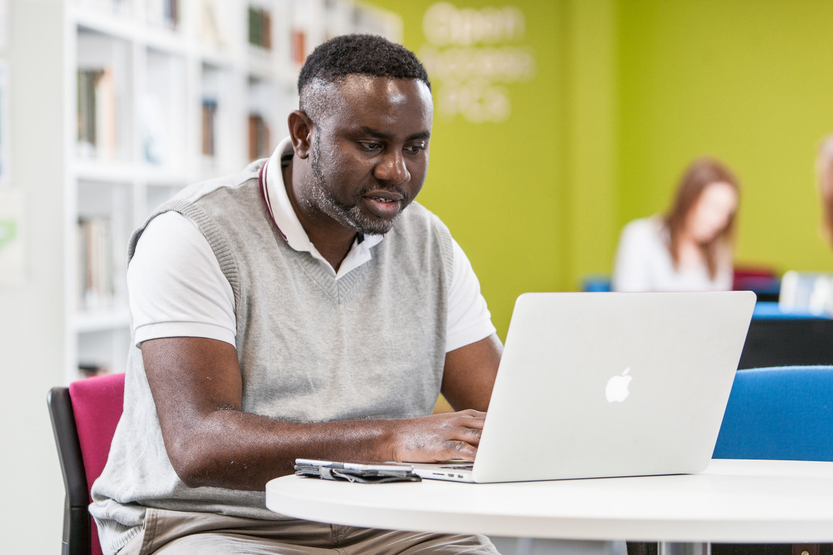 A student using a laptop at a desk