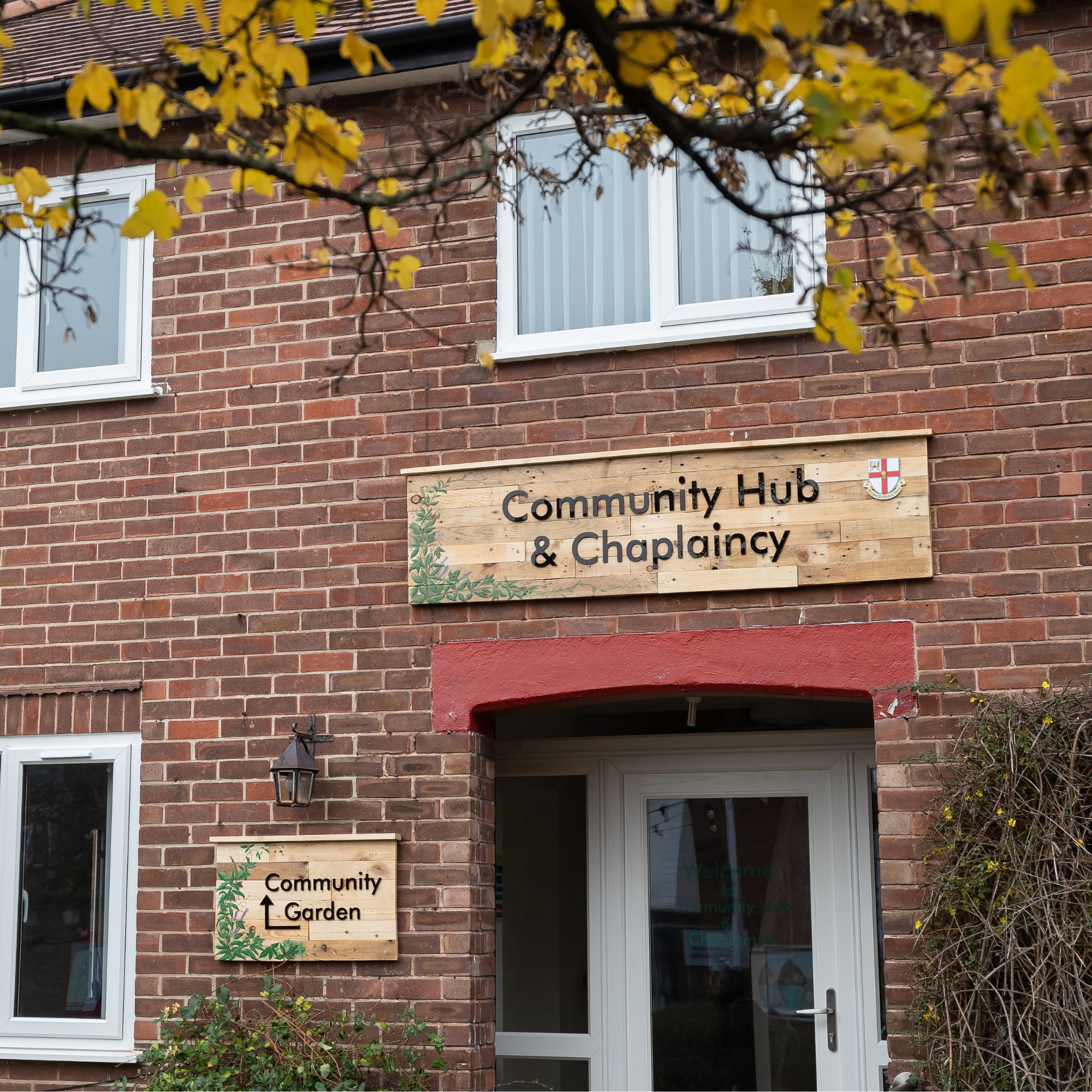 A brick building with a sign that reads Community Hub and a door